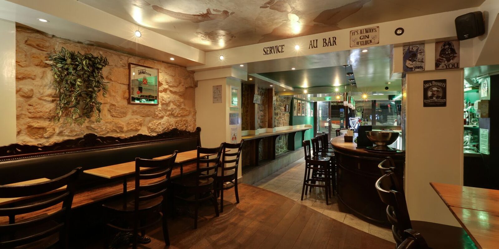Salle du rez-de-chaussée : pierre apparente et banquettes de cuir